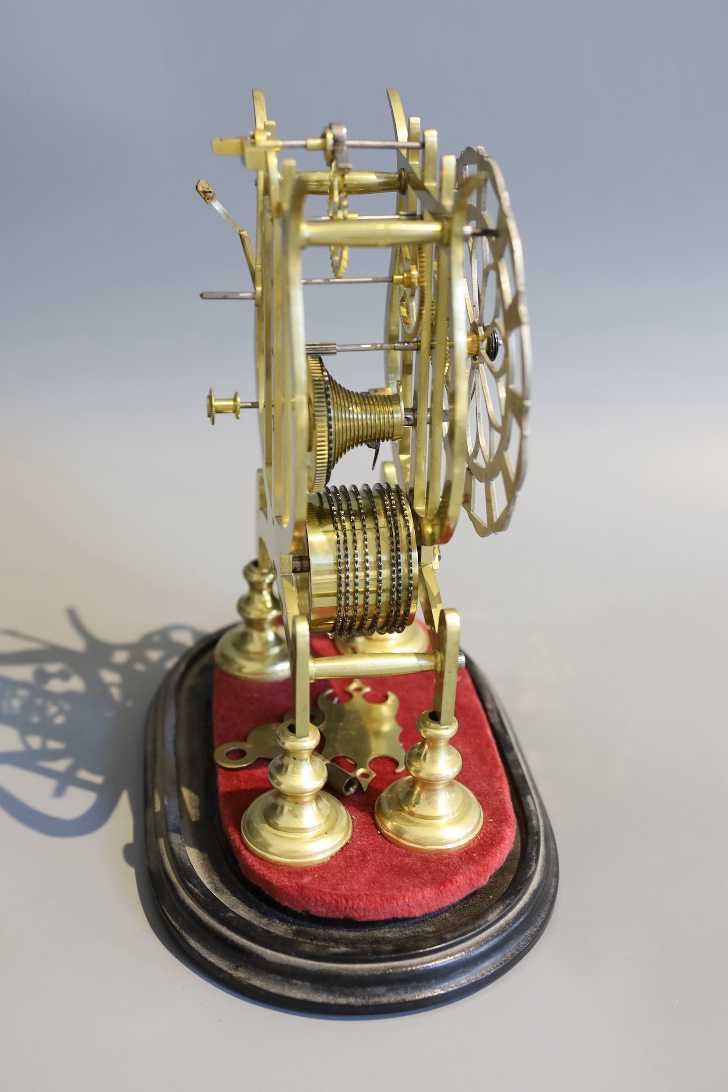 A 19th century brass skeleton mantel timepiece, under glass dome, with single fusee movement and pierced silvered chapter ring, height 24cm